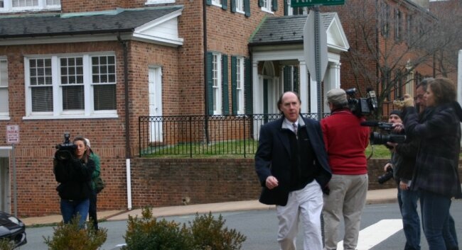 George Huguely IV, the father of the accused, hurries past a bank of photographers.