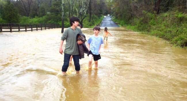 After their dads tested the water%2526#039;s depth and current, Charlie Manning and Blaze Prax brave an overflowed Dollins Creek on Plank Road near Batesville around 4:45pm Saturday.