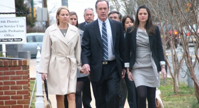 The Huguely family entourage bands together as they head down High Street toward the courthouse.