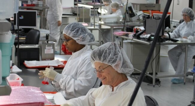 Happy MicroAire workers handle sterile medical devices in a %2526quot;clean room.%2526quot;
