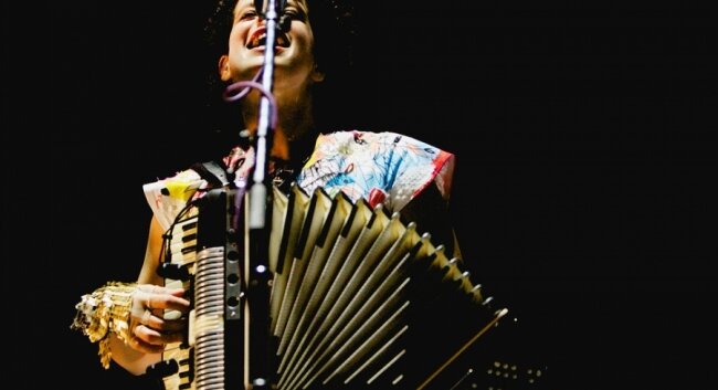 Accordion-playing multi-instrumentalist Regine Chassagne co-founded the band with husband Butler.
