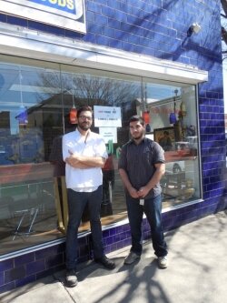 Wahid Rehim (right), and friend, in front of Grand Market International Foods and Grill. 