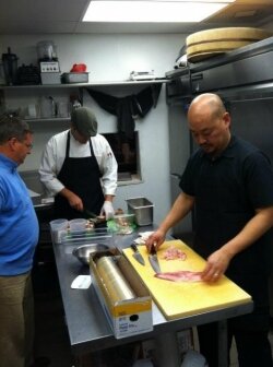 Ten chef Pei Chang (right) preps the hamachi tartar while his assistant Monty (background) trims the already roasted pork belly for Bourdain and Ripert, as Stu Rifkin looks on. 