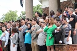 All 79 ceremony participants recite the Pledge of Allegiance for the first time as new citizens. 