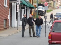 A police forensic team surveys the site of the March 16 shooting on Second Street NW in front of the Elks Lodge.