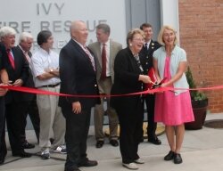 Albemarle County supervisors Ken Boyd, Rodney Thomas, Dennis Rooker, Duane Snow, and Ann Mallek (in pink), County Executive Tom Foley and County Fire Chief Dan Eggleston stand by as UVA President Teresa Sullivan cuts the ribbon at the county%2526#039;s new fire station.