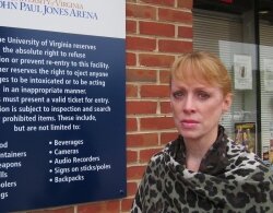 Gil Harrington stands next to signs at John Paul Jones Arena. As extensively reported in the Hook, her daughter, Morgan Harrington, was abducted and slain after leaving a Metallica concert in 2009 and being denied reentry.