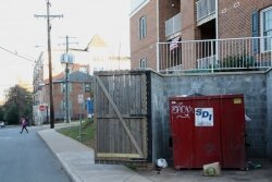 The dumpster, with Huguely%2526#039;s residence in the background.