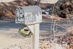 The welcoming flag on the mailbox belies the tragedy that unfolded on Rio Mills Road the day after Christmas.