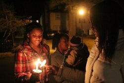 Dashad %2526quot;Sage%2526quot; Smith%2526#039;s cousin, Syndi Rush, right, and friend Jameka Wood, both 10th graders at CHS, lit candles as another of Smith%2526#039;s friends, Monique Fitch, stands by with baby Savion.