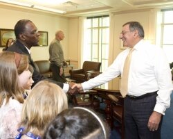 Surrounded by Agnor-Hurt Elementary fourth graders, World Peace Game creator John Hunter shakes hands with U.S. Secretary of Defense Leon Panetta.