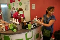Since Sweet Frog is self-serve, only one employee is needed on a typical Monday, Chloe Matheny shown here, who simply freshens the fixins bar and collects the dough.